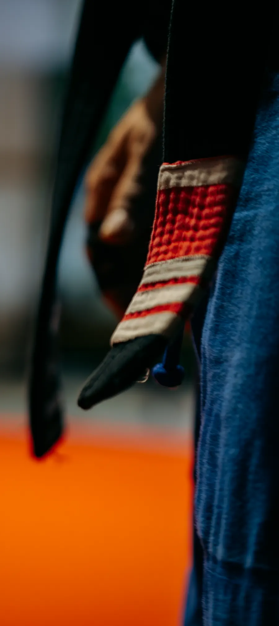 Detalle de un cinturón negro con la barra roja